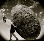 Image of business woman rolling a giant stone